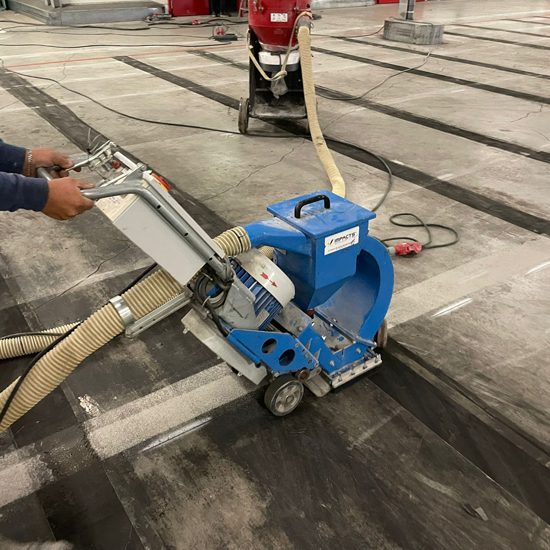 Kogelstraalmachine met slangen tijdens betonstraalwerk in Aalsmeer