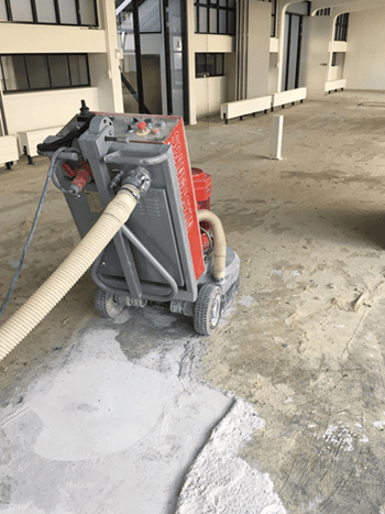 Betonvloer met lijmresten machinaal behandelen Betonvloer met lijmresten machinaal behandelen