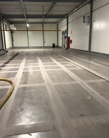 Behandelde betonvloer wordt na het kogelstralen schoongemaakt
