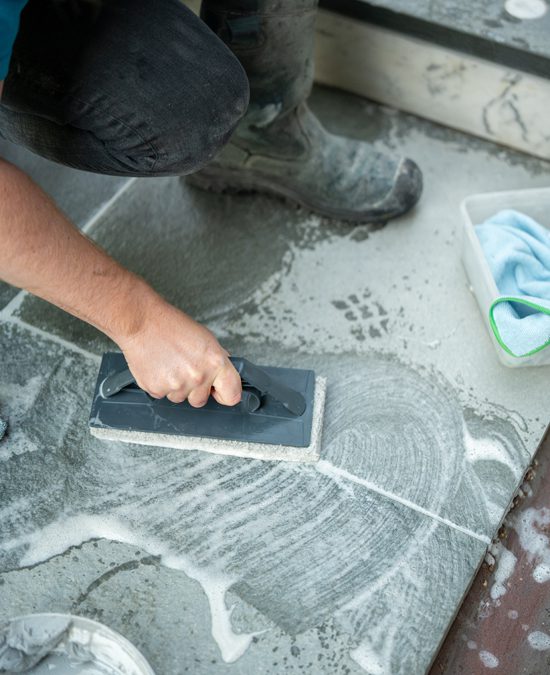 Medewerker behandelt een detail van de traptreden bij station Diemen Zuid