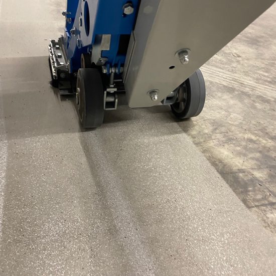Kogelstraalmachine verwijdert epoxycoating in één werkgang van een betonvloer