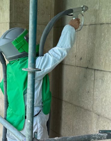 Medewerker behandelt een verticale Frans kalkstenen wand