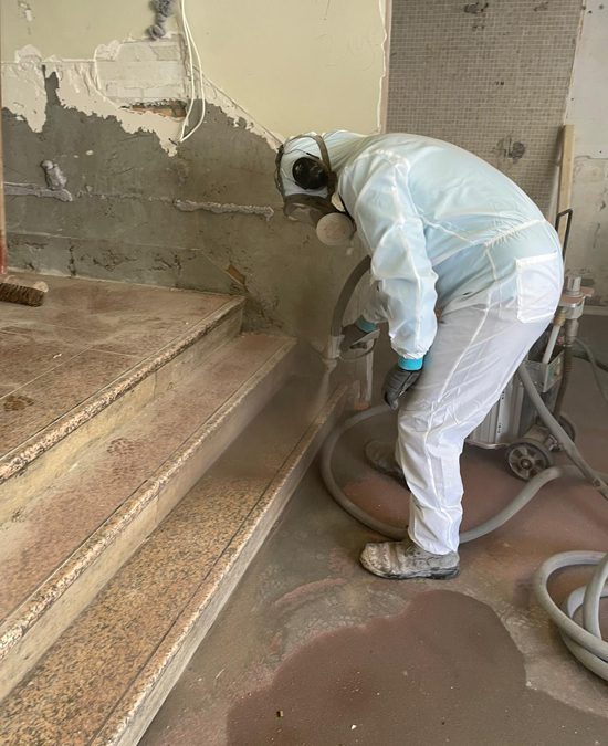 Medewerker straalt een granieten traptrede met professionele straalapparatuur