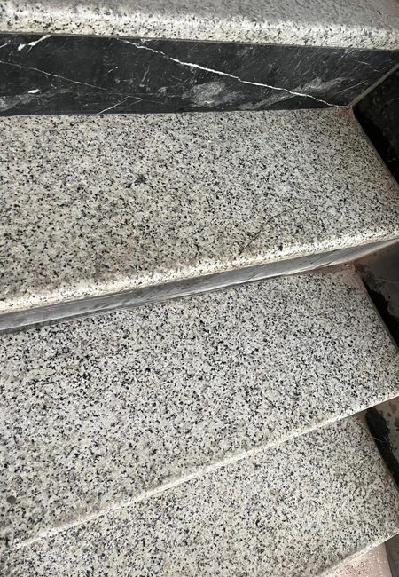 Gladde granieten traptreden vóór het stralen Detail van gladde granieten traptreden vóór de straalbehandeling