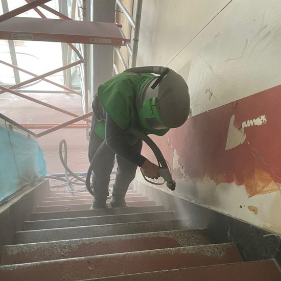 Granieten trap zandstralen in Eindhoven Medewerker straalt granieten traptreden bij McDonald’s Eindhoven