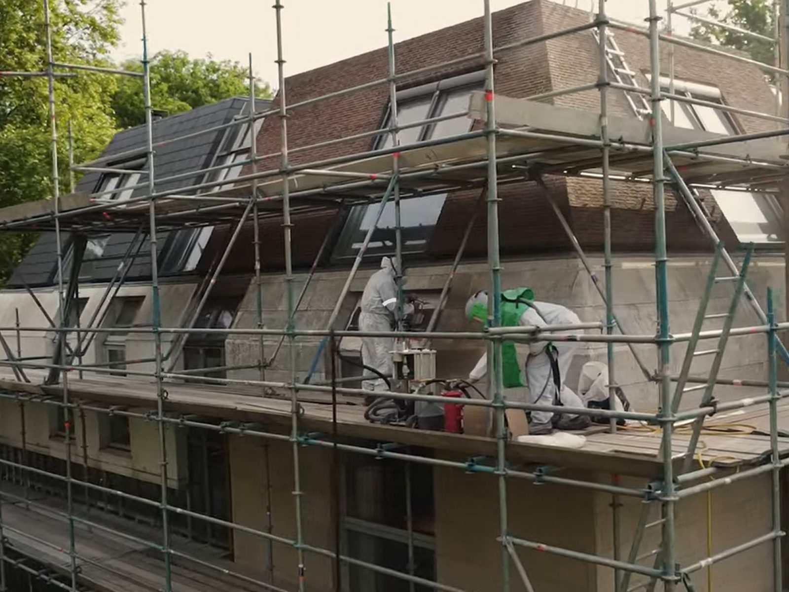 Landhuis met steigers voor het stralen van de kalkstenen gevel
