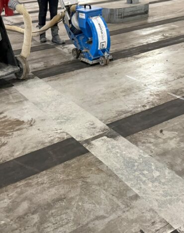 Oude coating en vloerbelijning verwijderd van betonvloer