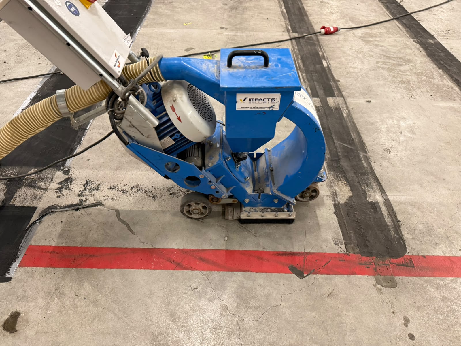 Kogelstraalmachine verwijdert oude vloerbelijning van betonvloer in Aalsmeer