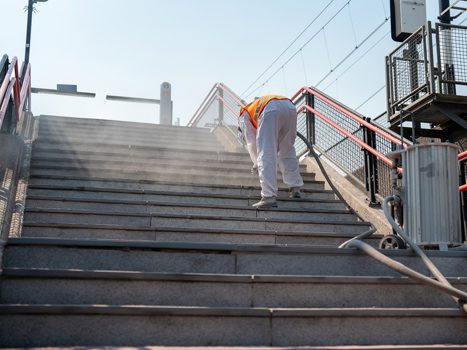 Medewerker reinigt en straalt trapdelen bij station Diemen Zuid