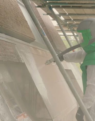Medewerker straalt verticale kalkstenen buitenwand